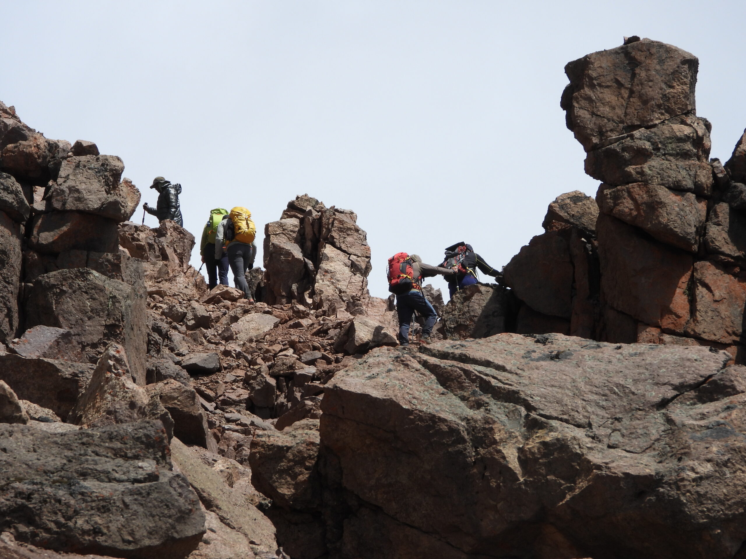 Group of trekkers climbing over steep rocky terrain in Mount Kenya’s alpine zone en route to Austrian Hut on the Chogoria–Sirimon route Group of trekkers climbing over steep rocky terrain in Mount Kenya’s alpine zone en route to Austrian Hut on the Chogoria–Sirimon route