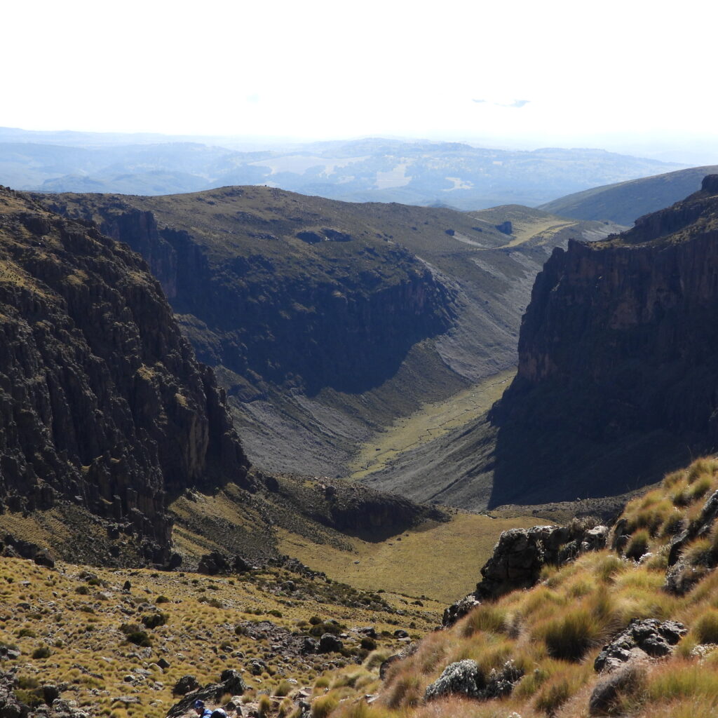 The dramatic Gorges Valley on Mount Kenya’s Chogoria Route, viewed from above with steep cliffs and a grassy valley floor