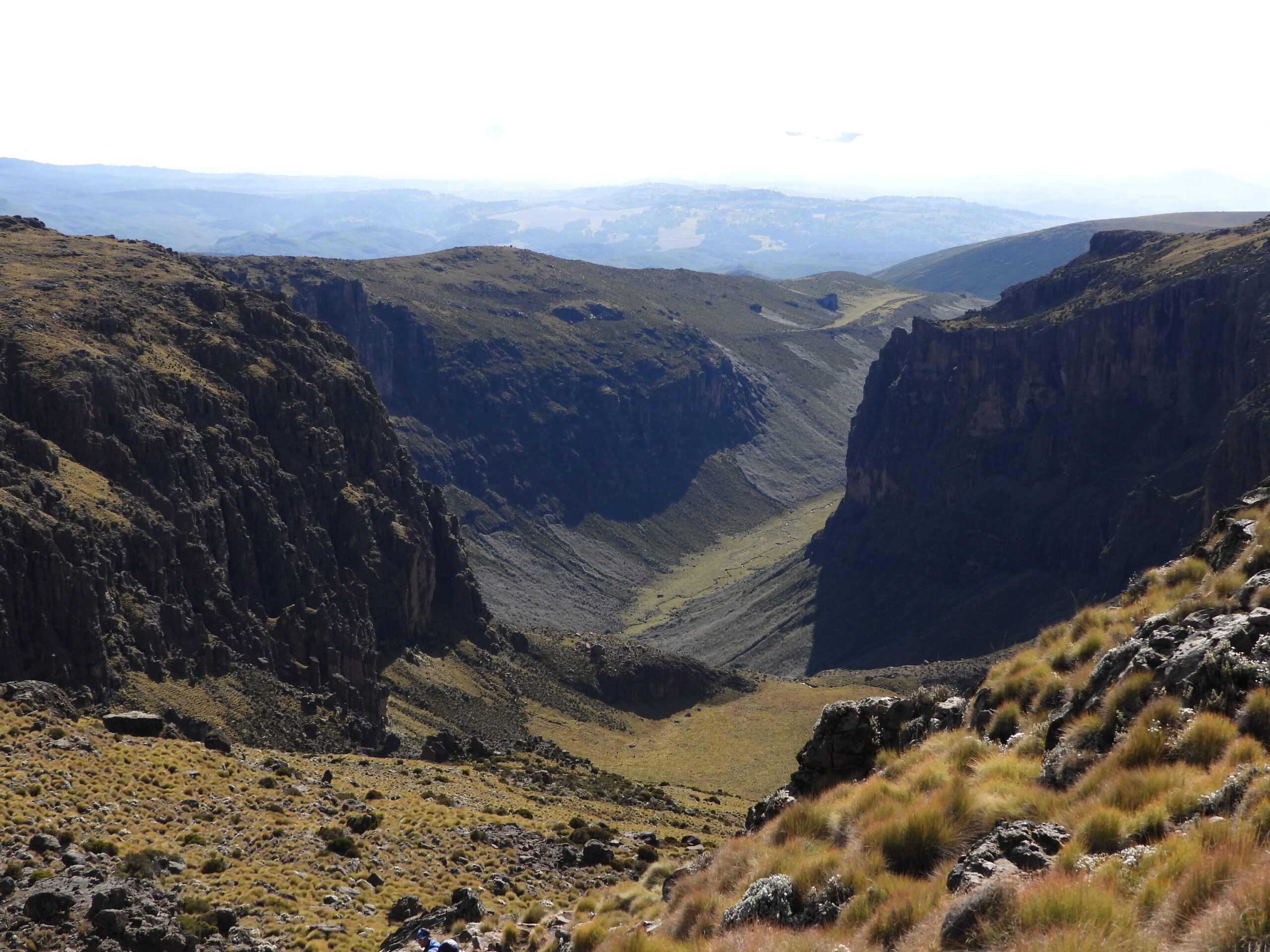 The dramatic Gorges Valley on Mount Kenya’s Chogoria Route, viewed from above with steep cliffs and a grassy valley floor The dramatic Gorges Valley on Mount Kenya’s Chogoria Route, viewed from above with steep cliffs and a grassy valley floor