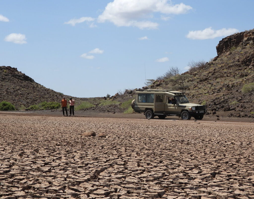 Ahambi Tours 4x4 safari vehicle on the cracked earth of the Chalbi Desert, Northern Kenya Tour — remote desert expedition