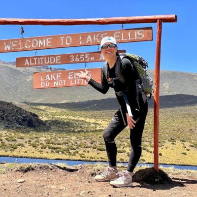 Trekker at the Lake Ellis welcome sign at 3,455m on the 2-day Mount Kenya trek via Chogoria Route — Ahambi Tours