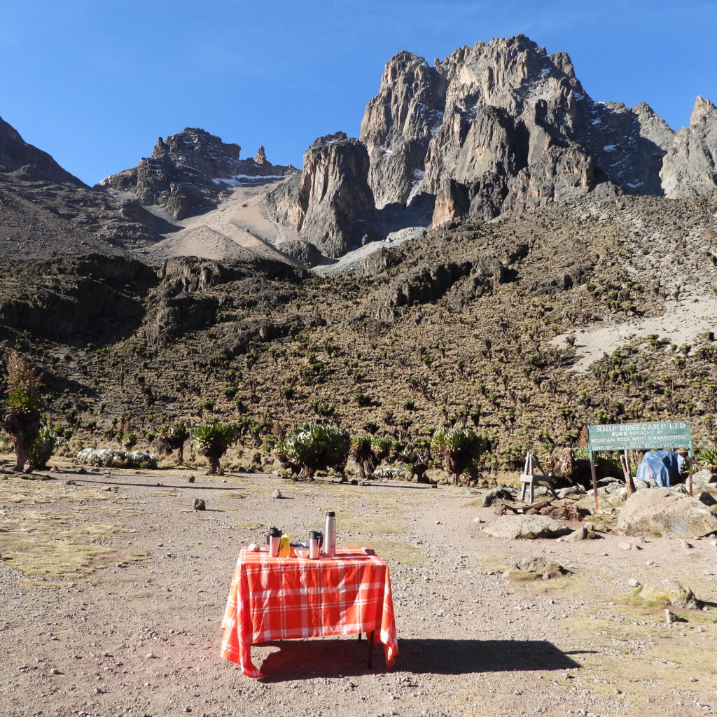 Morning tea setup at Shipton’s Camp on Mount Kenya with views of Batian and Nelion peaks