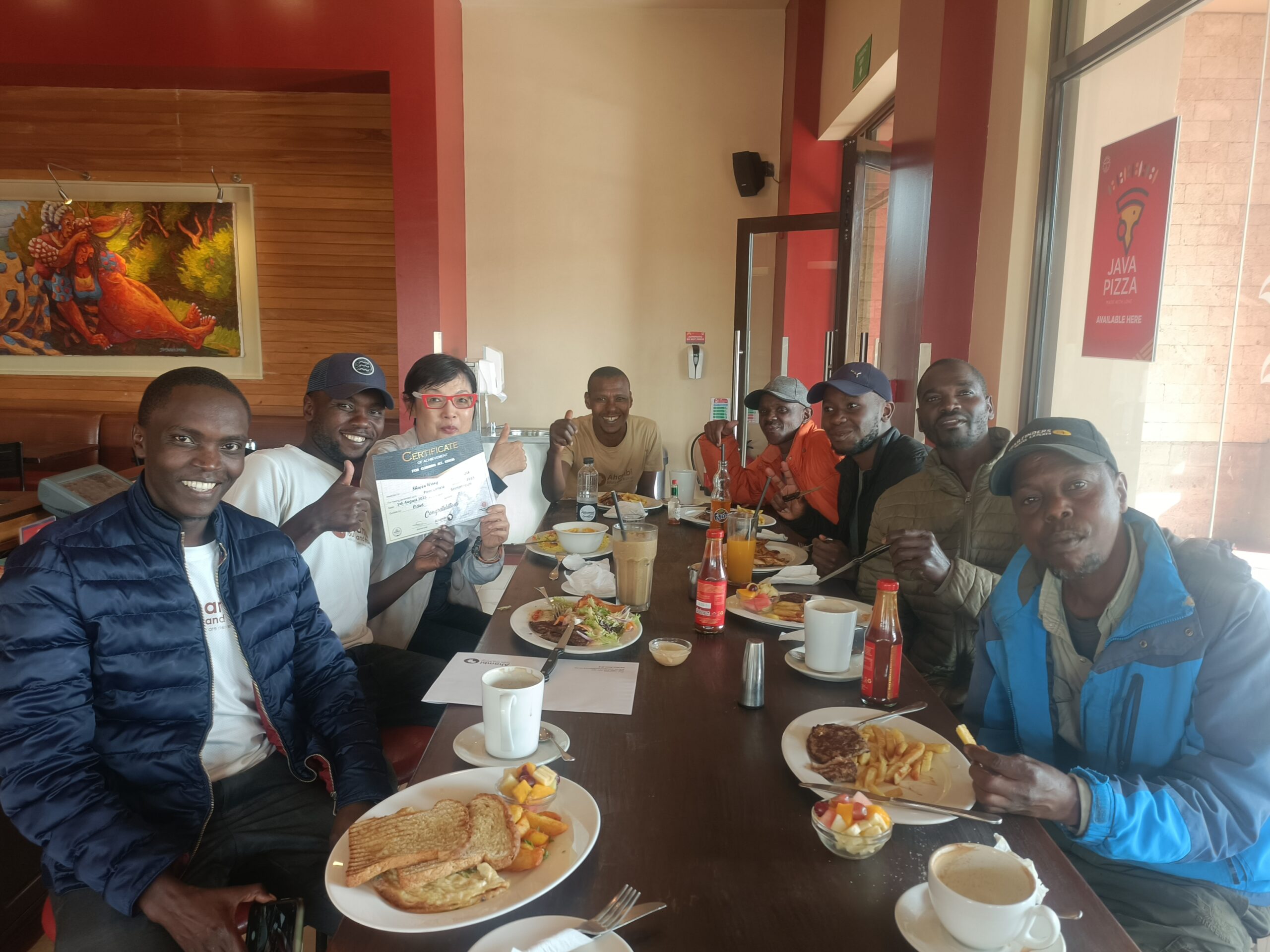 Ahambi Tours Mount Kenya trekking team enjoying a celebratory lunch after a successful Point Lenana summit via the Sirimon Route with a guest over 60 years old